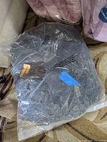 Grey orthopedic dog bed by Alpha Paw sealed in original plastic packaging. Partially transparent packaging shows the textured fabric and Alpha Paw branding on an orange tag.