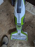 Top view of Bissell Crosswave wet dry vacuum cleaner showing handle and front brush area on a wooden floor.