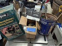 Portable utility pump with owner's manual and gardening tools in bucket and box