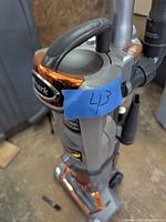 Front and side view of the Shark Professional vacuum cleaner showing brand logos, handle, and dust cup with orange accents.