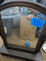 Front view of the tabletop wooden mirror showing arched top and reflective mirror pane.