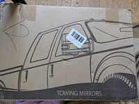 Cardboard box with printed truck image and 'TOWING MIRRORS' text on front.