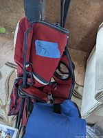 Red regular folding camping chair showing fabric seat with mesh side pockets and tubular metal frame.