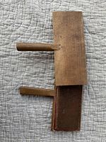 Two wooden cotton carders placed on a textured fabric background. Shows the full length of the carders and their wooden handles.