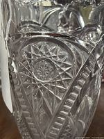 Close-up of intricate starburst and geometric pattern etched into glass, showing clarity and detail of the antique pitcher.