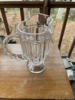 Full view of the antique clear pattern glass water pitcher showing overall shape and design.