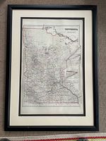 Framed 1886 Minnesota map showing the full state within beige mat and black frame with visible surface and overall condition