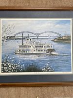 Front view of the framed Memphis Queen III riverboat print, showing the detailed boat and river scene with floral foreground and bridge in the background.