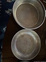 Metal camping plate and bowl with signs of wear and extensive use.