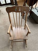 Front view of wooden child's rocking chair showing the wood finish and shape