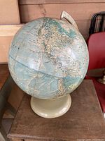 Full view of the vintage cream base globe showing North and South America with visible wear.