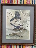 Full view of framed Blue Jays art print by Basil Ede, showing the birds above a water stream with snowy background in wood frame.
