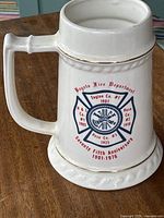 Side view of white ceramic mug showing fire department insignia with text 'Bogota Fire Department, Engine Co. #1, Hose Co. #1, Hose Co. #3, 75th anniversary 1901-1976' and gold trim.