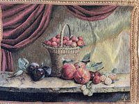 Close up of tapestry showing basket of apples and assorted fruit on table with draped background.