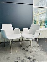 Front-facing view of two chairs side by side against a dark wall.