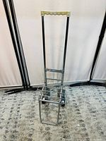 Front view of Sparco compact luggage cart showing chrome metal structure, black grip handle, and compact frame.