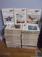 Large stack of American Heritage magazines from 1960s and 1970s, showing front covers with historical art