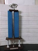 Full view of the 1960s Connecticut Dragway trophy showing its overall tall structure with blue vertical panels and car figure on top.