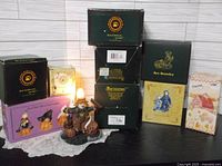 Photo showing 10 items including Boyds Halloween themed figurines and 7 original boxes stacked on a white doily against a white wall.