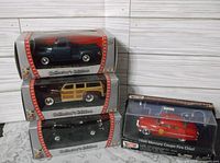 Four 1:43 scale die-cast model cars including three Road Signature editions and one Moto Max Mercury Coupe Fire Chief in packaging.