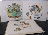 Photo shows three vintage Norman Rockwell prints, approximately 13 x 10 inches, arranged side by side. Scenes depicted include family fireplace dinner, children with animals, and romantic couple. Used condition visible.