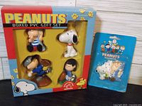 Overview of the boxed Peanuts PVC gift set and Peanuts magnets in original packaging.