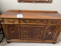 Front view showing full buffet with carved drawer fronts and central drawers