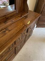 Top angled view of the dresser showing wood surface, drawer details, and brass handles
