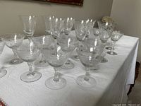 All 20 Tostoria Romance etched glassware pieces arranged on a white tablecloth with 3 distinct sizes of stemware visible.