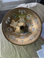 Top view of the bowl showing detailed hand-painted floral designs and gold embellishments on amber-colored glass.