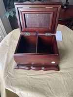 Top view of the wooden box with the lid open showing the interior divided into two compartments and glass photo frame on the lid.