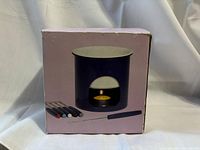Photo of the boxed fondue pot, stand and six forks showing the components of the set.