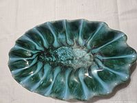 Top view of the oval serving dish showing blue and green glaze with fluted edges and glossy surface.