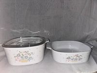 Photo of two ceramic Corningware casseroles side by side, one with glass lid.