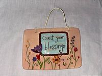 Front view of the vintage decorative wall plaque with 'Count your blessings' text and floral elements.