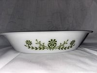 Side view of the white Glasbake cookware dish showing the green floral pattern on the exterior side.