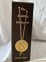 Photo of the binder spine showing brown cover with gold pressing and knitting design