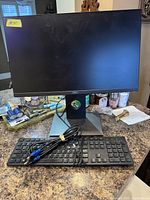 Dell 22-inch monitor on counter with keyboard and cable bundled on top.