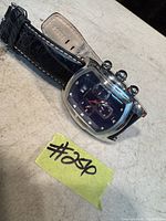 Men's Invicta watch laid flat to show side view, strap, and watch case shape.