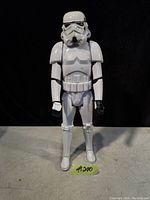 Front-facing image of a white Stormtrooper action figure from Star Wars standing upright on a gray surface with a black background.