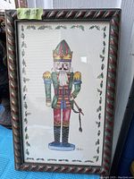 Frontal view of the framed nutcracker watercolor painting showing full artwork and decorative frame.