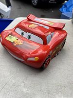 Front view of red Lightning McQueen shaped electronic toy laptop for kids modeling a race car character from Disney Pixar Cars 2.