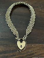 Full view of multi-strand chain and padlock clasp laid flat