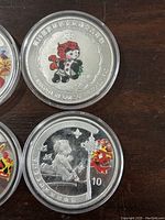 Close-up of two Olympic tokens showing a mascot and child with lion design