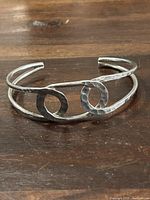 Front perspective of the hammered sterling silver open cuff bangle bracelet showing loop design.