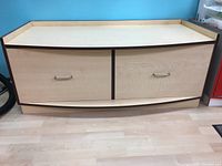 Front view of custom laminated curved front cabinet with two drawer fronts and metal handles.