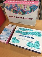 Box for Janome Miraclestitcher Yarn Embroidery kit showing colorful packaging with stylized text and blue-green embroidery patterns.