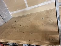 Stack of plywood sheets viewed at an angle, showing full sheets in new condition.