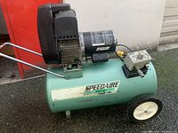 Full side view of the green Speedaire direct drive air compressor showing motor, tank, wheels, and handle.