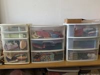 Three stacked Sterilite plastic drawer units containing assorted fabrics.